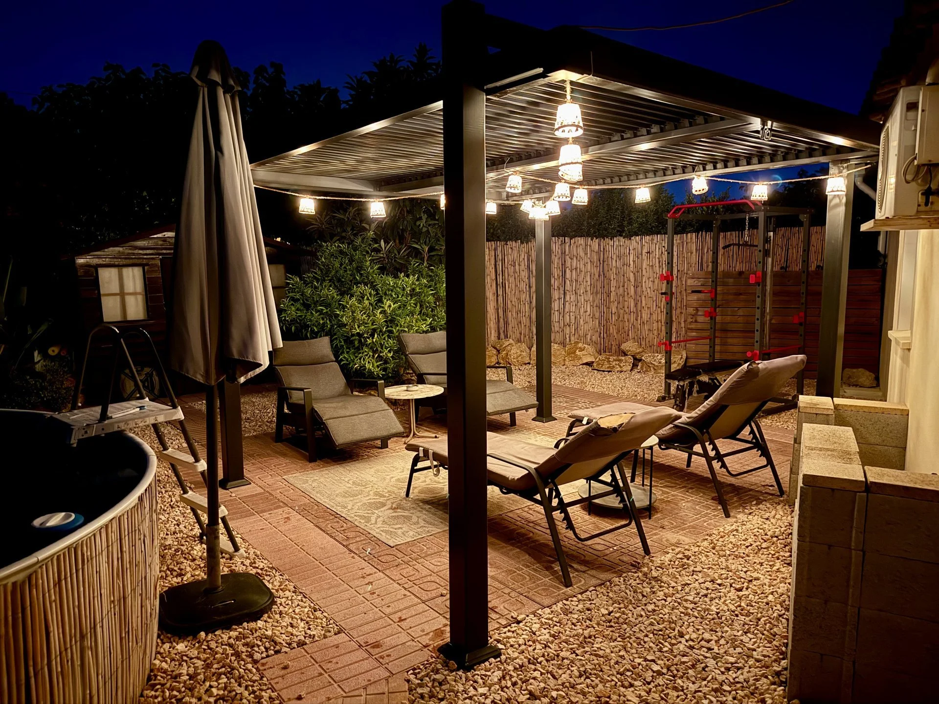 Ligstoelen bij het zwembad in de avond